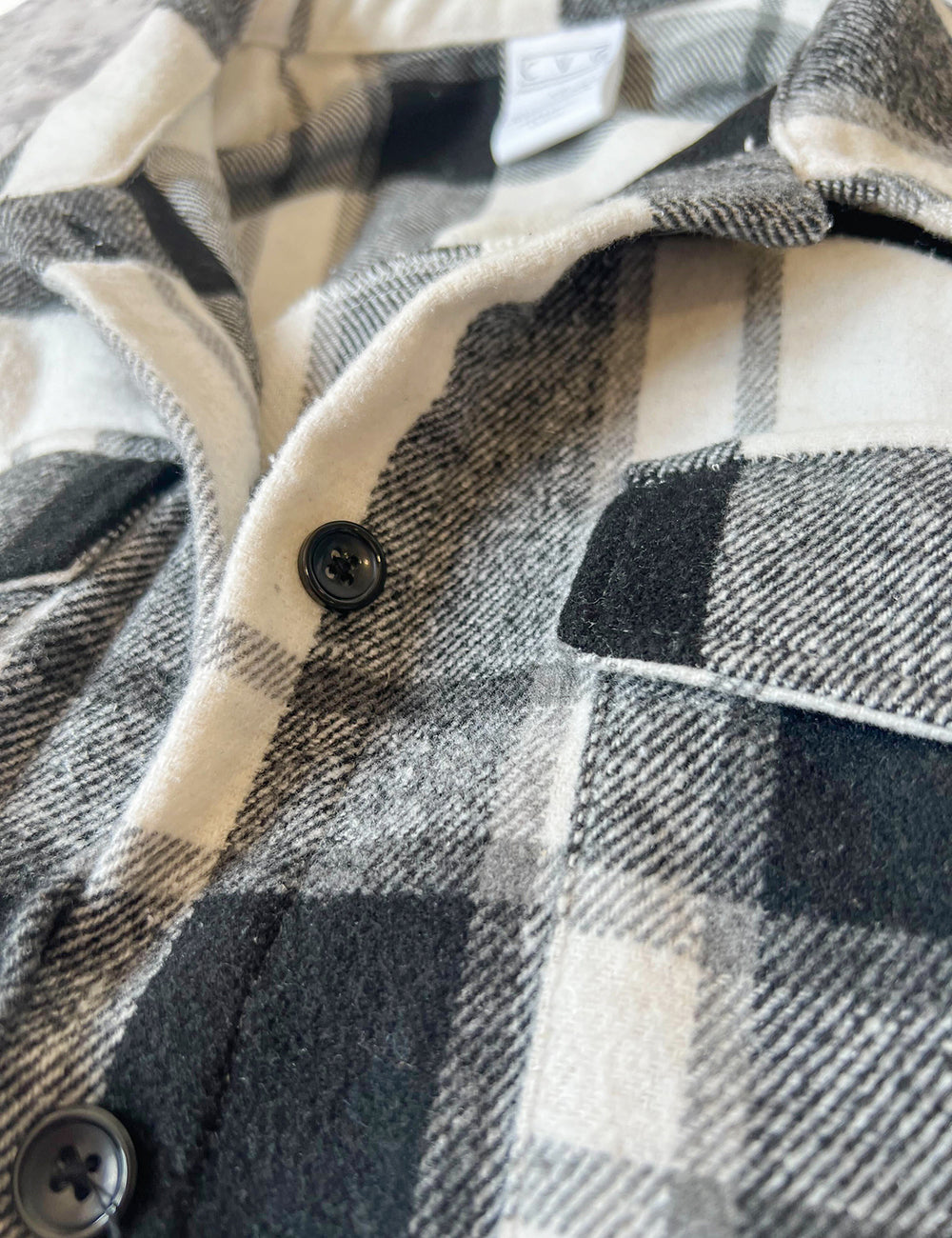close up of the black, grey, and white plaid jacket
