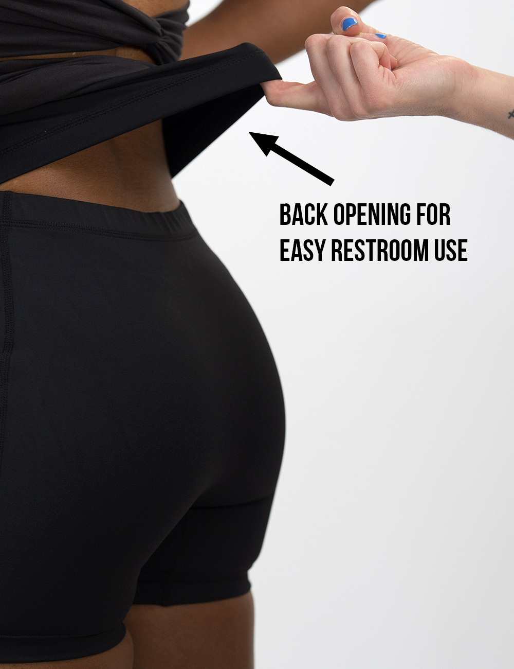 back of the black activewear dress lifted up to show the shorts lining underneath against a white background