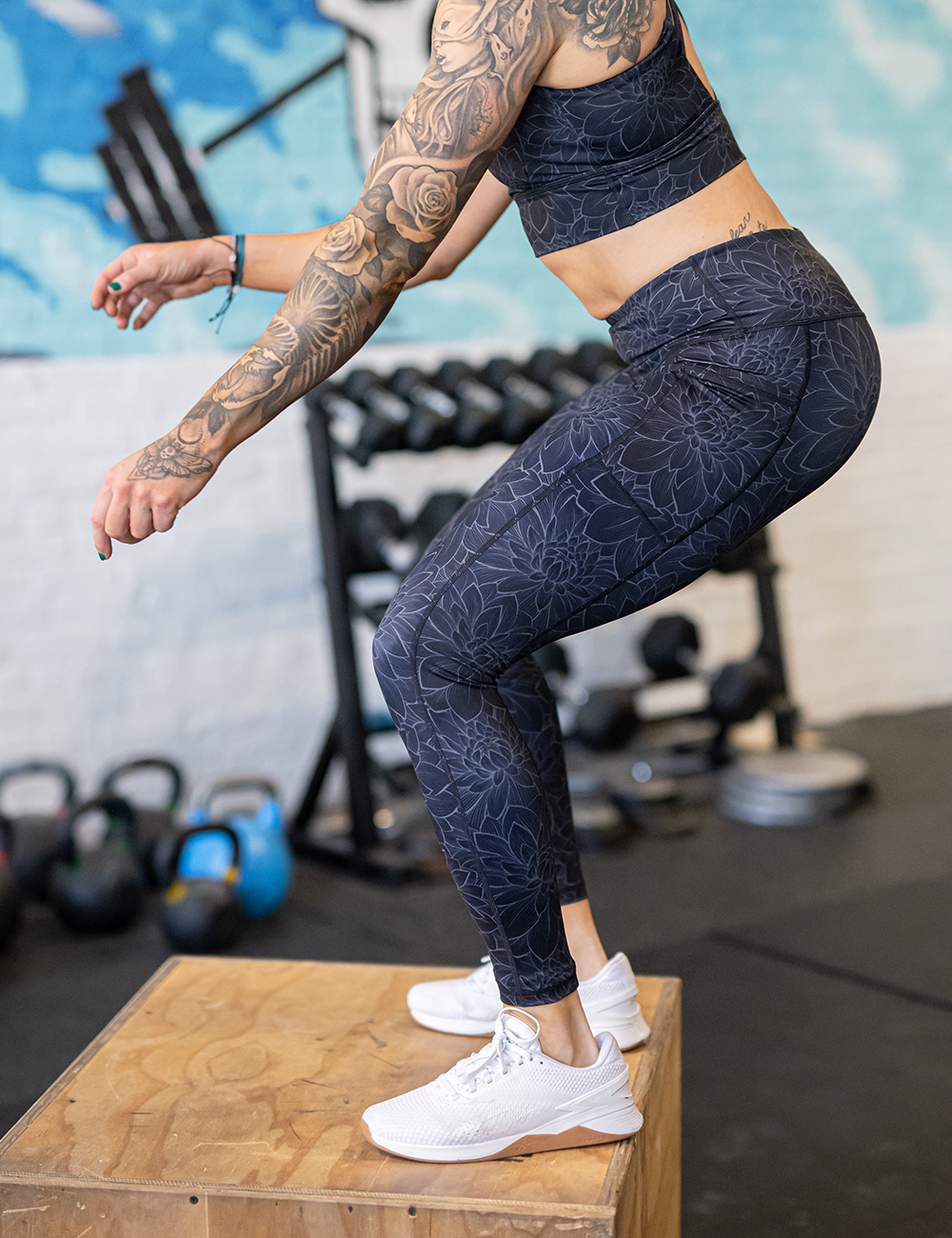 model wearing the etched lotus full length leggings against a black background in the gym
