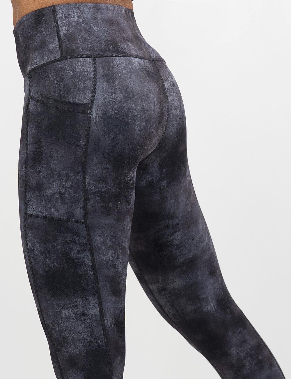 back of the black and grey grunge concrete pattern leggings against a white background