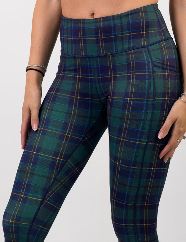 close up of the front of the blue, green, and yellow plaid leggings against a white background