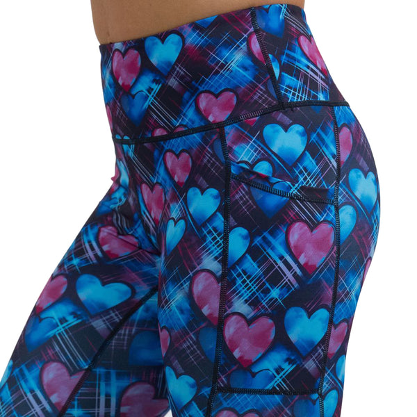 close up of blue and pink hearts pattern against a dark stitched background leggings
