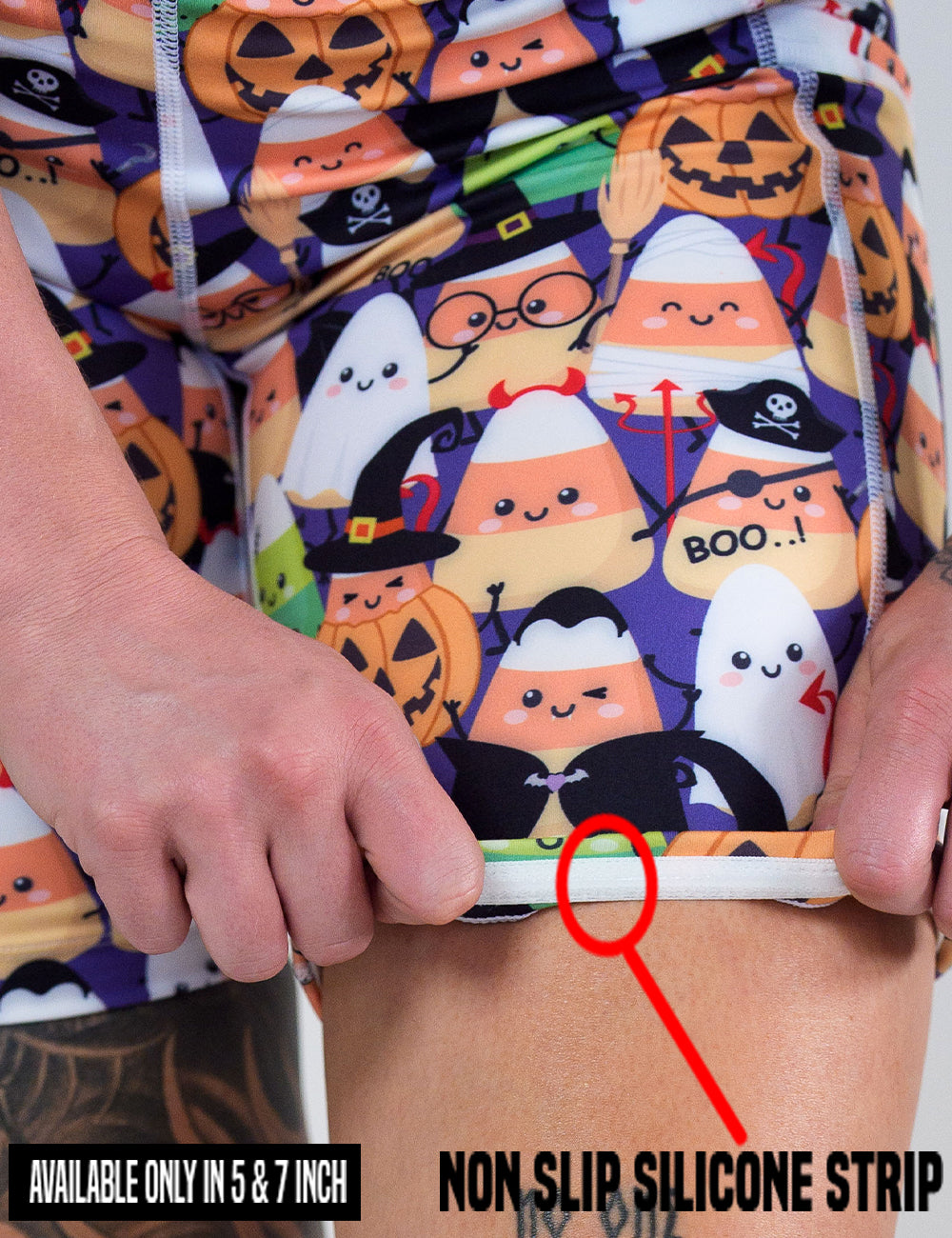 close up of the halloween candy corn patterned shorts being rolled up to show the non slip silicone strip found in the 5 and 7 inch shorts