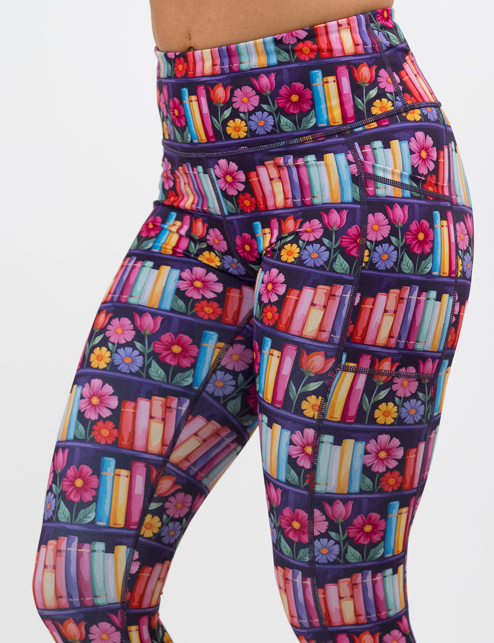 close up of the brightly colored books and flowers leggings against a white background