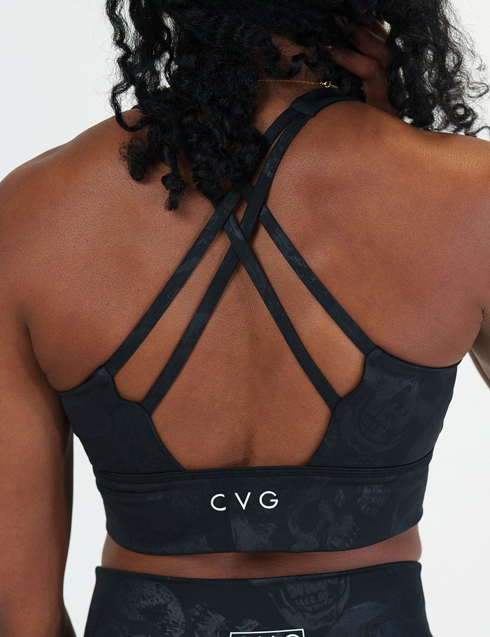 back of the black longline bra with a dark grey skull pattern against a white background