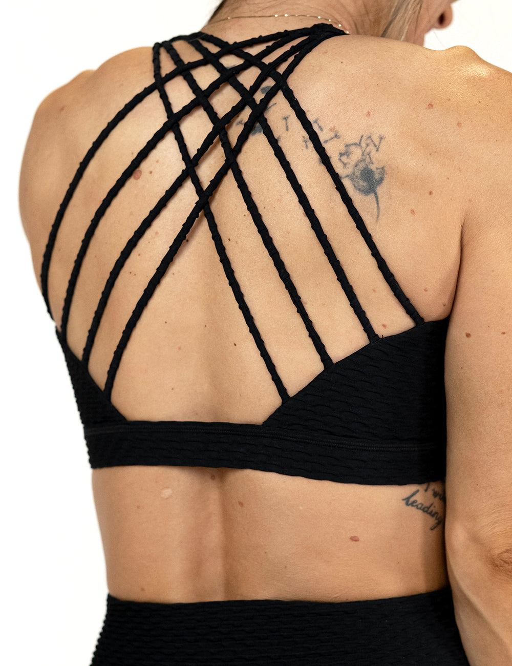 back of the black waffled texture bra against a white background