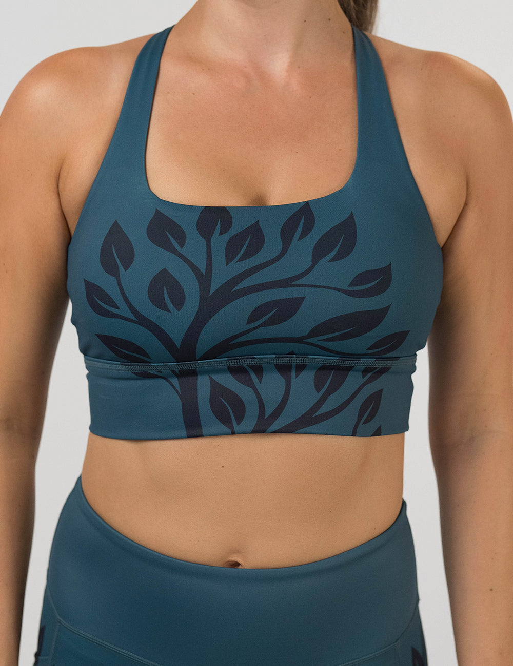 front of the Teal sports bra with black leaf pattern on a white background