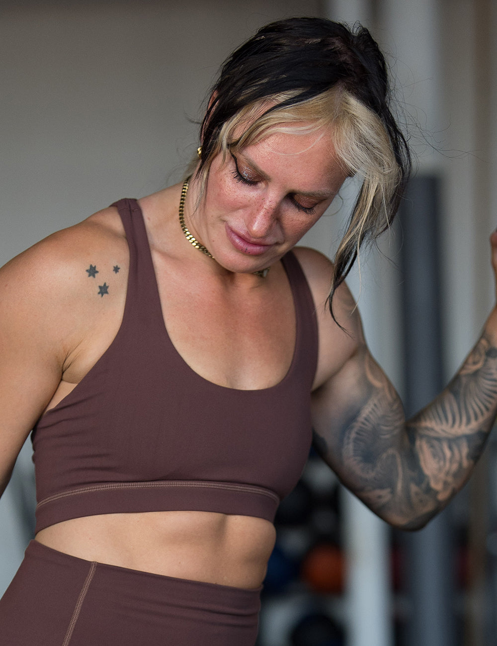 model wearing the solid light brown sports bra in the gym