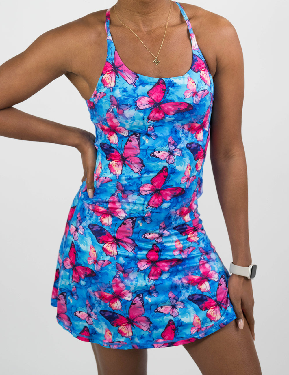 Woman wearing a blue and pink butterfly-patterned dress on a white background