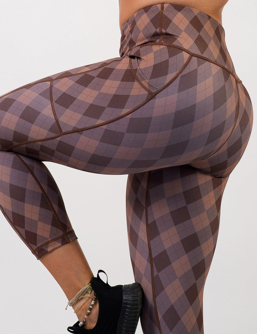 back of the grey, beige, and dark red plaid leggings against a white background