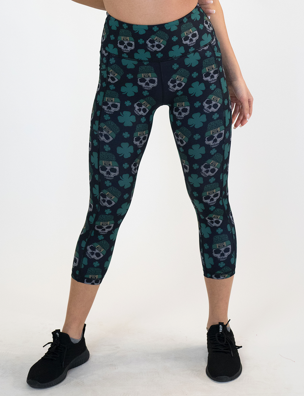 model wearing the capri shamrock and skull pattern leggings against a white background
