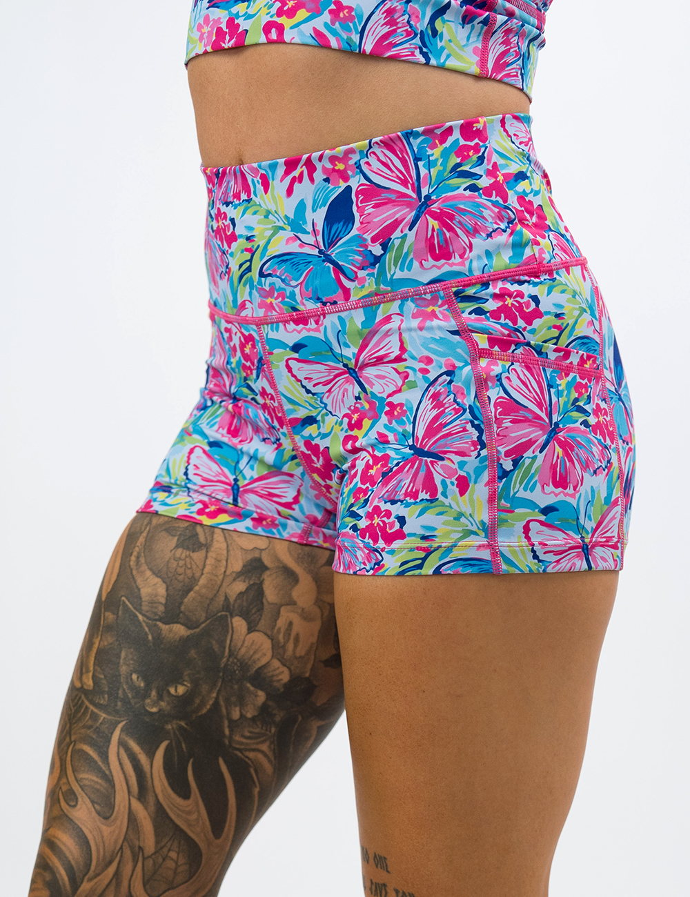 front of the pink butterflies against a colorful floral background 2.5 inch shorts