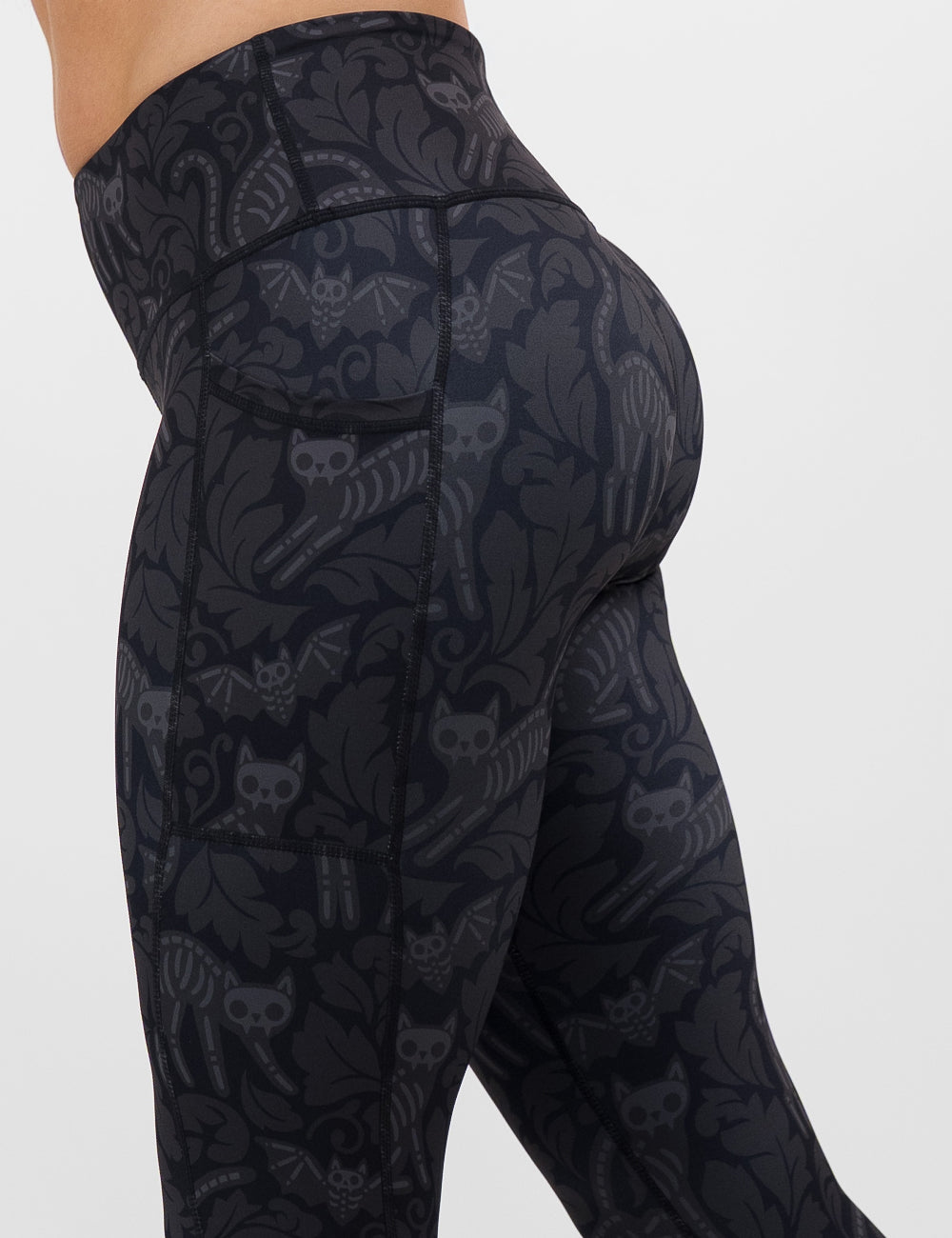 side view of the black and grey bats and cats skeletons leggings against a white background