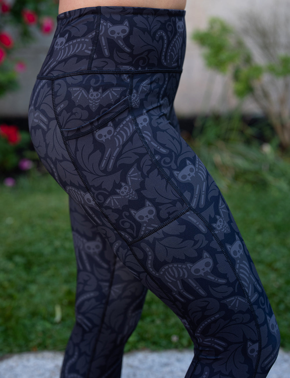 side view of the black and grey bats and cats skeleton leggings