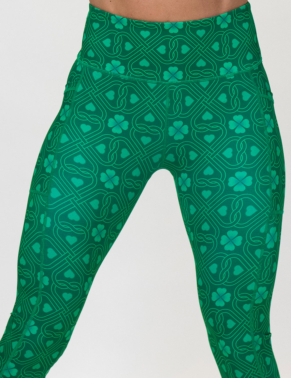 green celtic knots patterned leggings against a white background