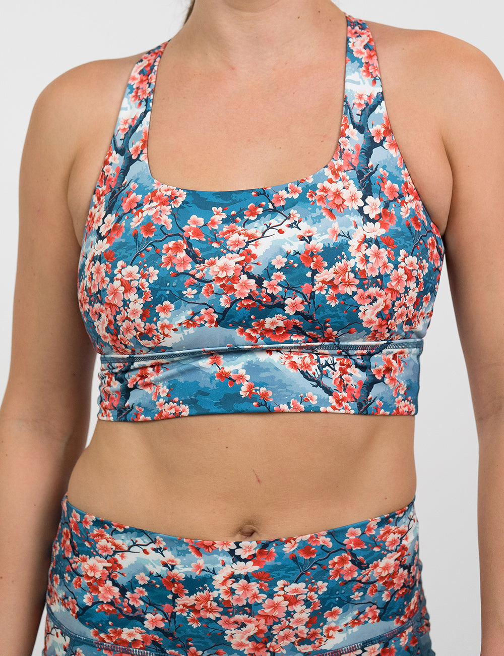 front of blooming cherry tree print longline bra against a white background