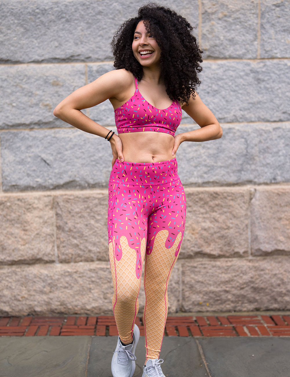 model wearing the pink ice cream cone with sprinkles full length leggings against a stone wall