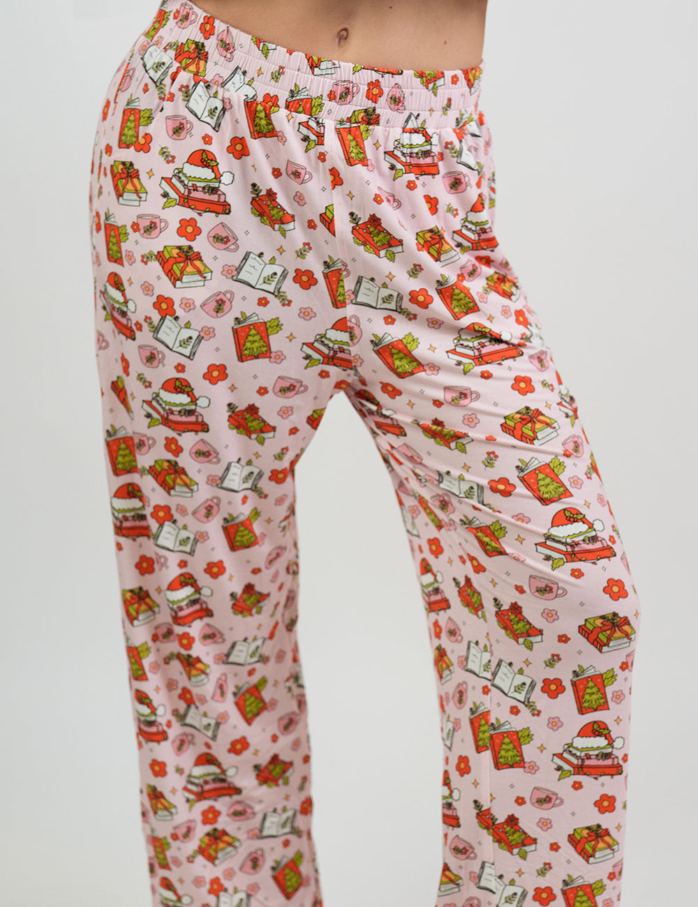close up of the Christmas books and flowers all over pink pajama bottoms