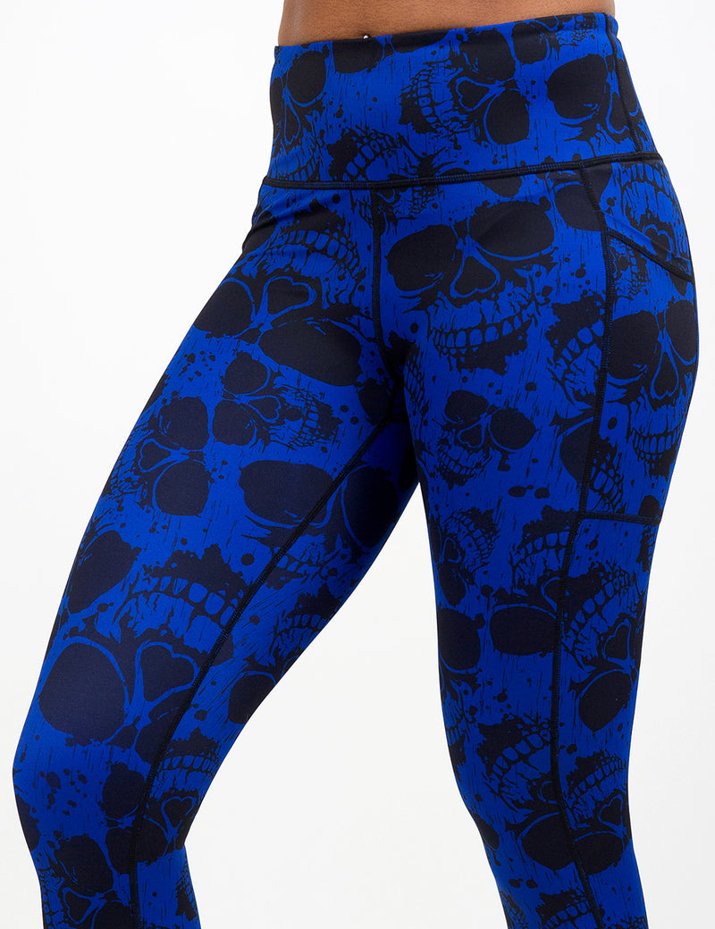 close up of the dark skulls against a blue background pattern leggings against a white background