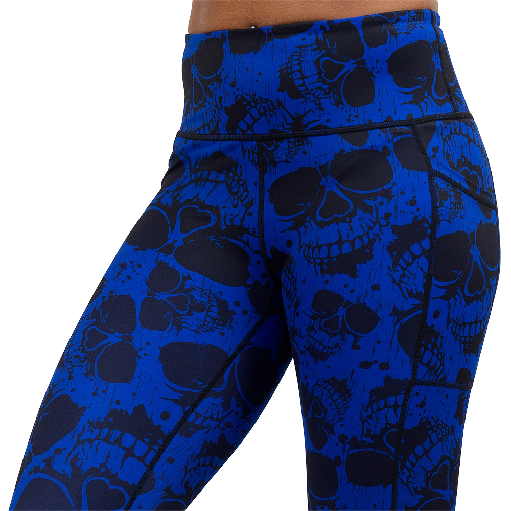 close up of the dark skulls against a blue background pattern leggings against a white background