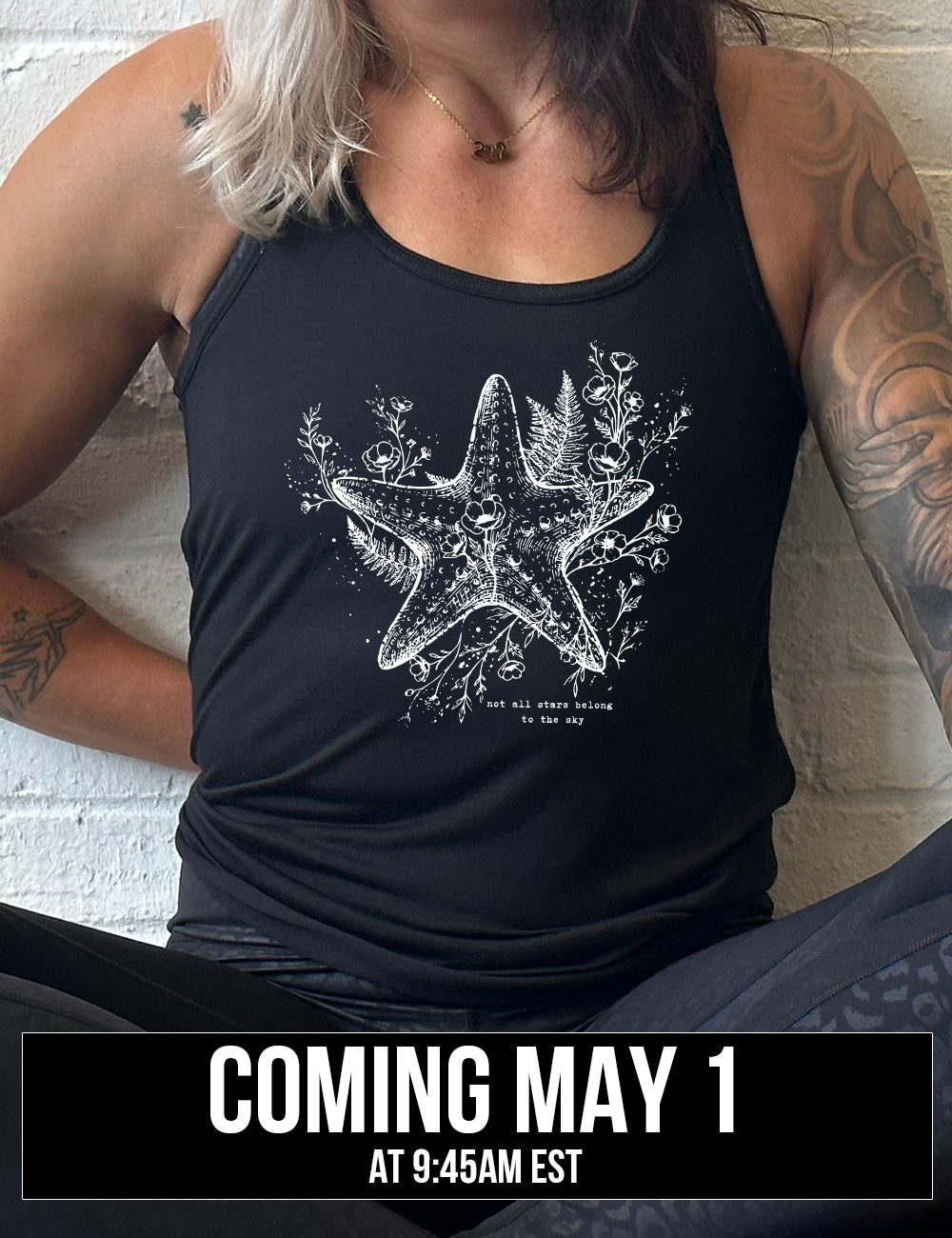 black racerback flowy tank with the graphic of a very detailed starfish among sea plants and flowers, with little bubbles, and the small words underneath it all that say "not all stars belong to the sky", coming soon