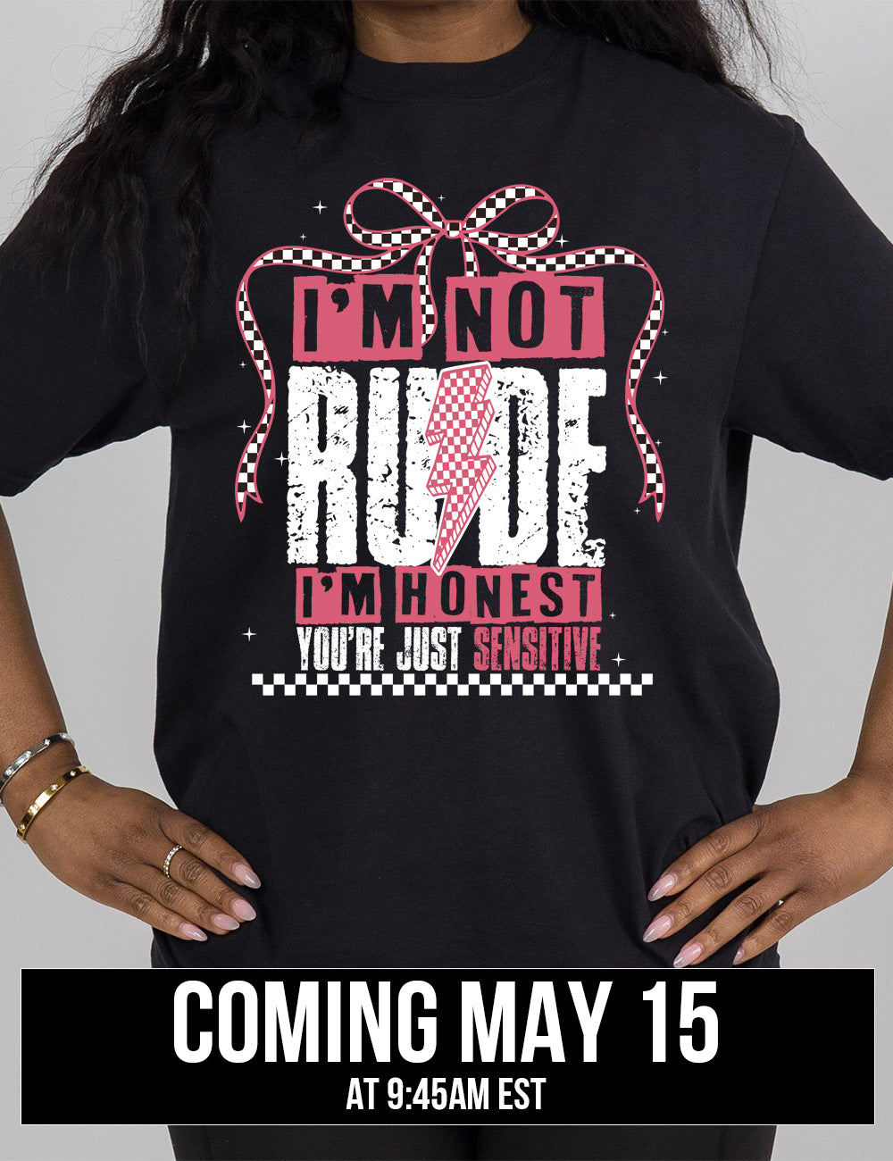 black modern tee with print placement on the front, in punk style, with the words "I'm not rude I'm honest you're just sensitive" on it, with a checkered lightning bolt in the middle of the word "rude" and a checkered bow arching over the words, and a checkered band below them, and a few small stars scattered around, coming may 15th