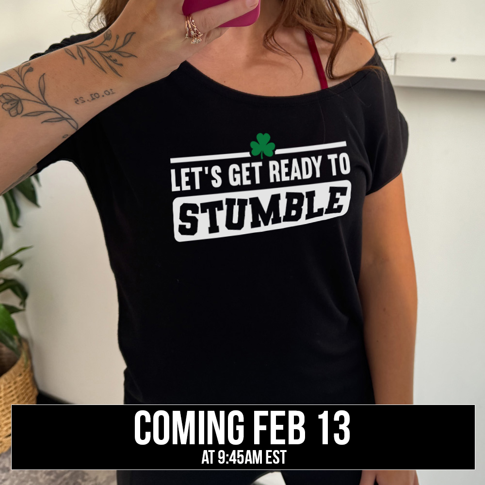 black slouchy tee with the words "let's get ready to stumble" on it, with one little shamrock graphic, and the word "stumble" in a rectangular block, and the letters leaning in different directions, coming soon