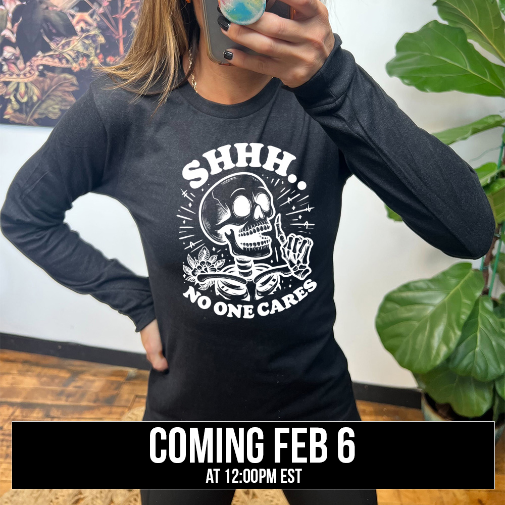 heather black long sleeve with the words "Shhh.. no one cares" on it, with the graphic of a skeleton holding a finger to its lips, coming soon
