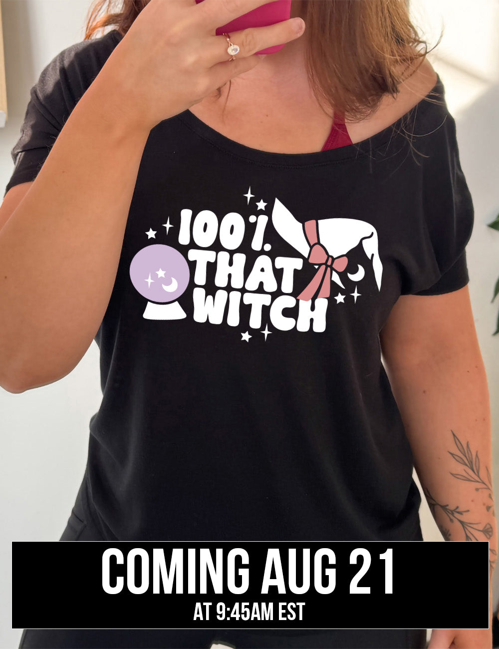 black slouchy tee with the words "100% that witch" next to the graphic of a witch hat with a bow, a crystal ball, and some stars, coming august 21st