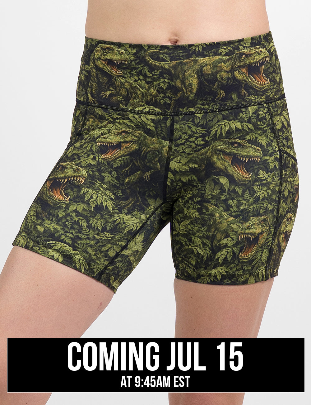 front of the 5 inch t-rex in a rainforest shorts against a white background, coming july 15th