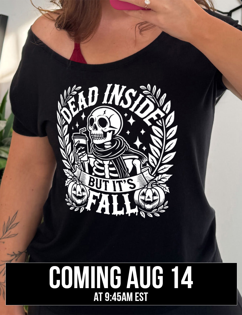 black slouchy tee with the words "dead inside but it's fall" on it, with plants framing the sides, two jack-o-lantern graphics, and the large graphic in the middle of a skeleton, wearing a scarf and holding a takeaway drink with a straw, and a few stars, coming august 14th