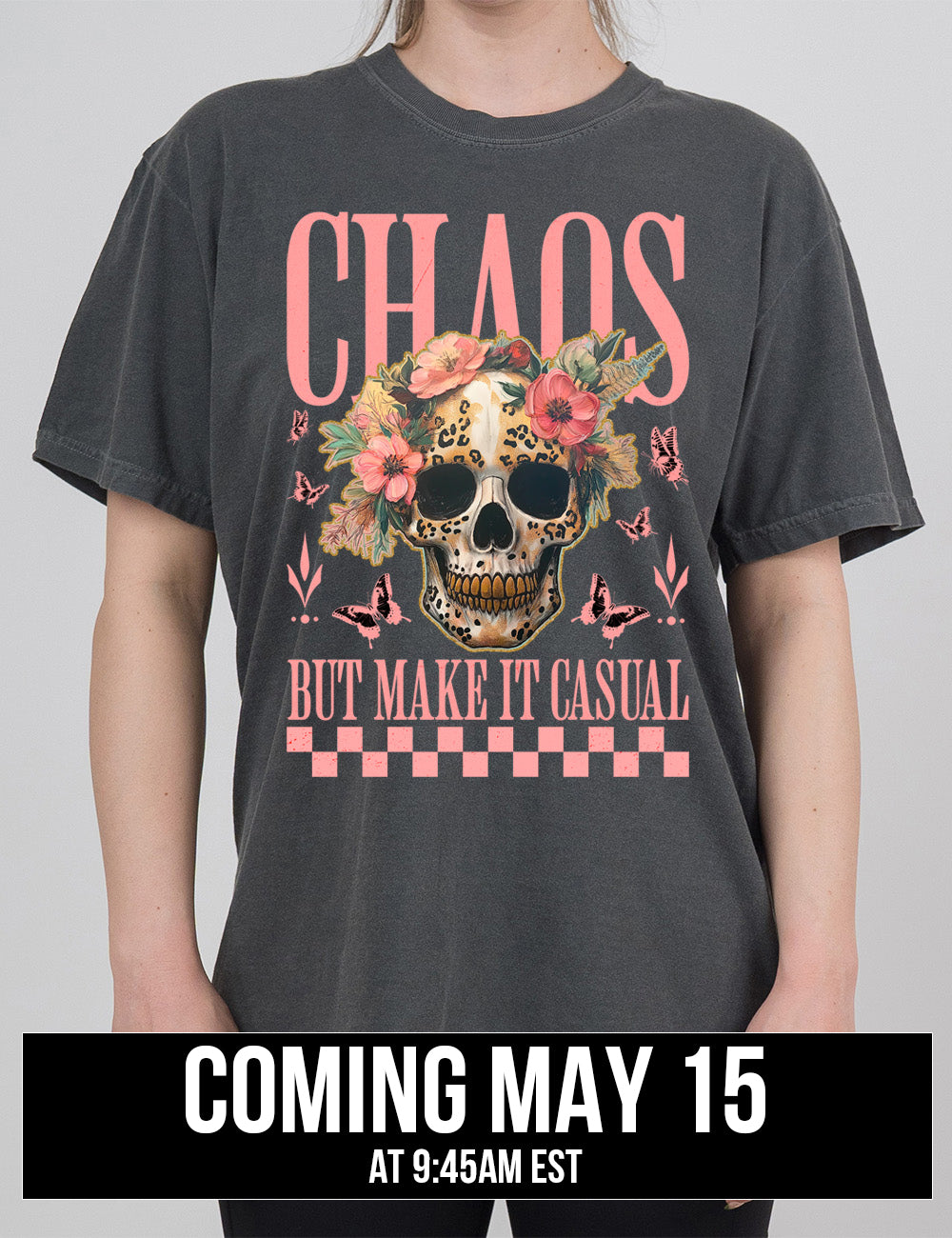 pepper modern tee with the print placement on the front, with the large word "chaos" on it, with the smaller words "but make it casual," and the graphic in between this of a gold-toothed skull with some leopard print, with a crown of flowers, surrounded by butterflies, coming may 15th
