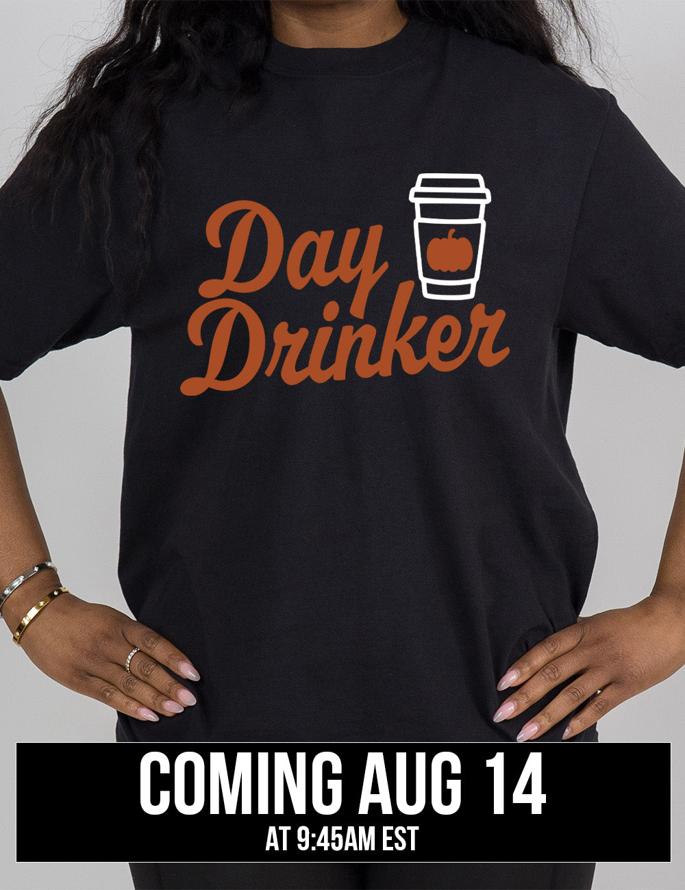 black modern tee with the words "day drinker" on it, with the graphic of a takeaway coffee cup with a pumpkin on the cup's sleeve, coming august 14th