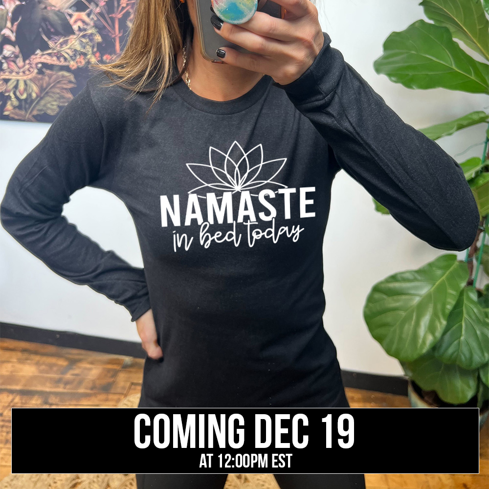 Heather black long sleeve shirt with the words "Namaste in bed today" with a line art of a lotus flower above it