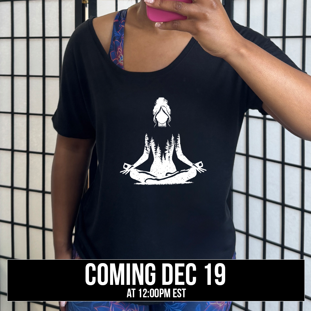Black slouchy shirt with the graphic of a woman doing a yoga pose, with her shoulders to waist being the silhouette of a forest  