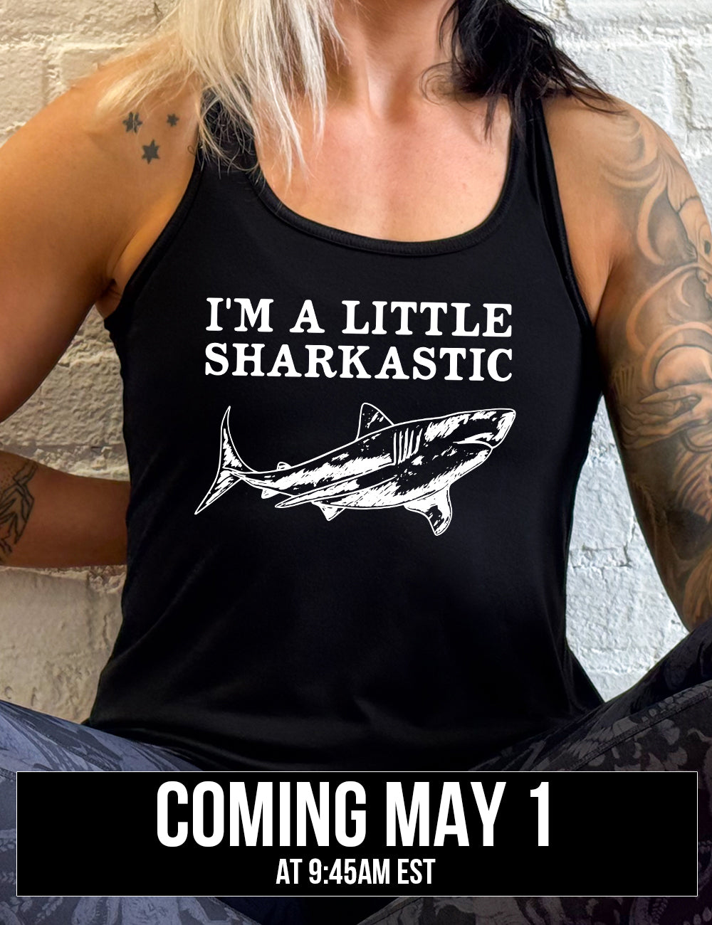 black racerback flowy tank with the words "I'm a little sharkastic" on it, over the graphic of a shark, coming soon