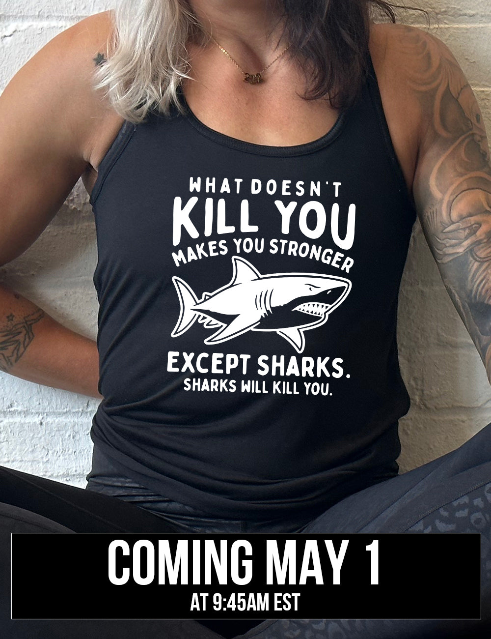 black racerback flowy tank with the words "what doesn't kill you makes you stronger except sharks. sharks will kill you." and the graphic of a fierce shark in the middle, coming soon