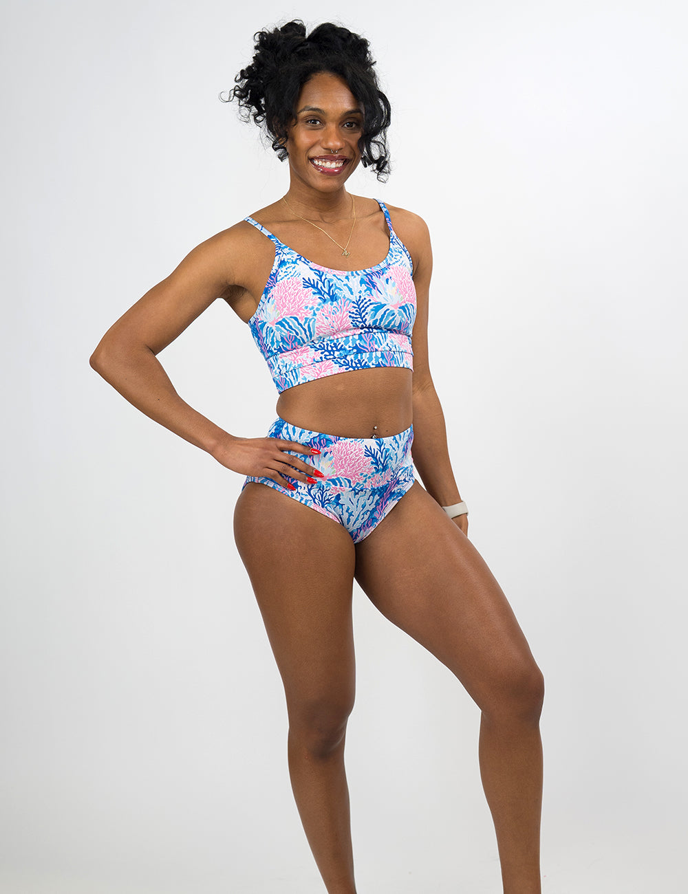 model wearing the blue and pink coral pattern coastline bathing suit bottoms against a white background