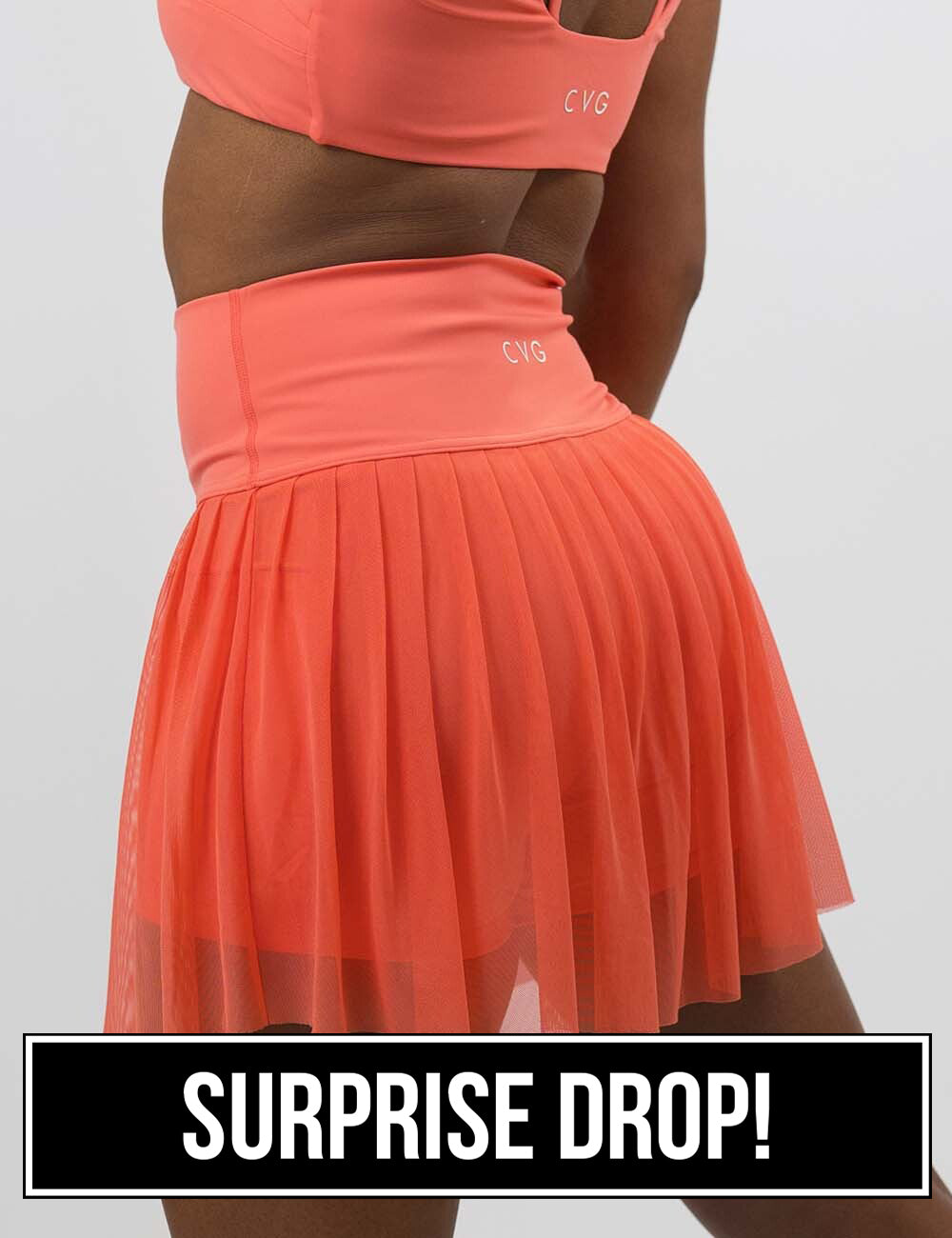 front of the sheer orange skirt against a white background, surprise drop