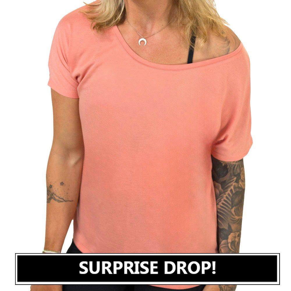 coral off-shoulder top worn by a person on a white background with 'SURPRISE DROP!' text at the bottom.