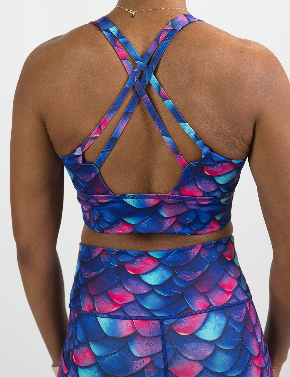 back of the blue, purple, and red colored dragon scale longline bra against a white background