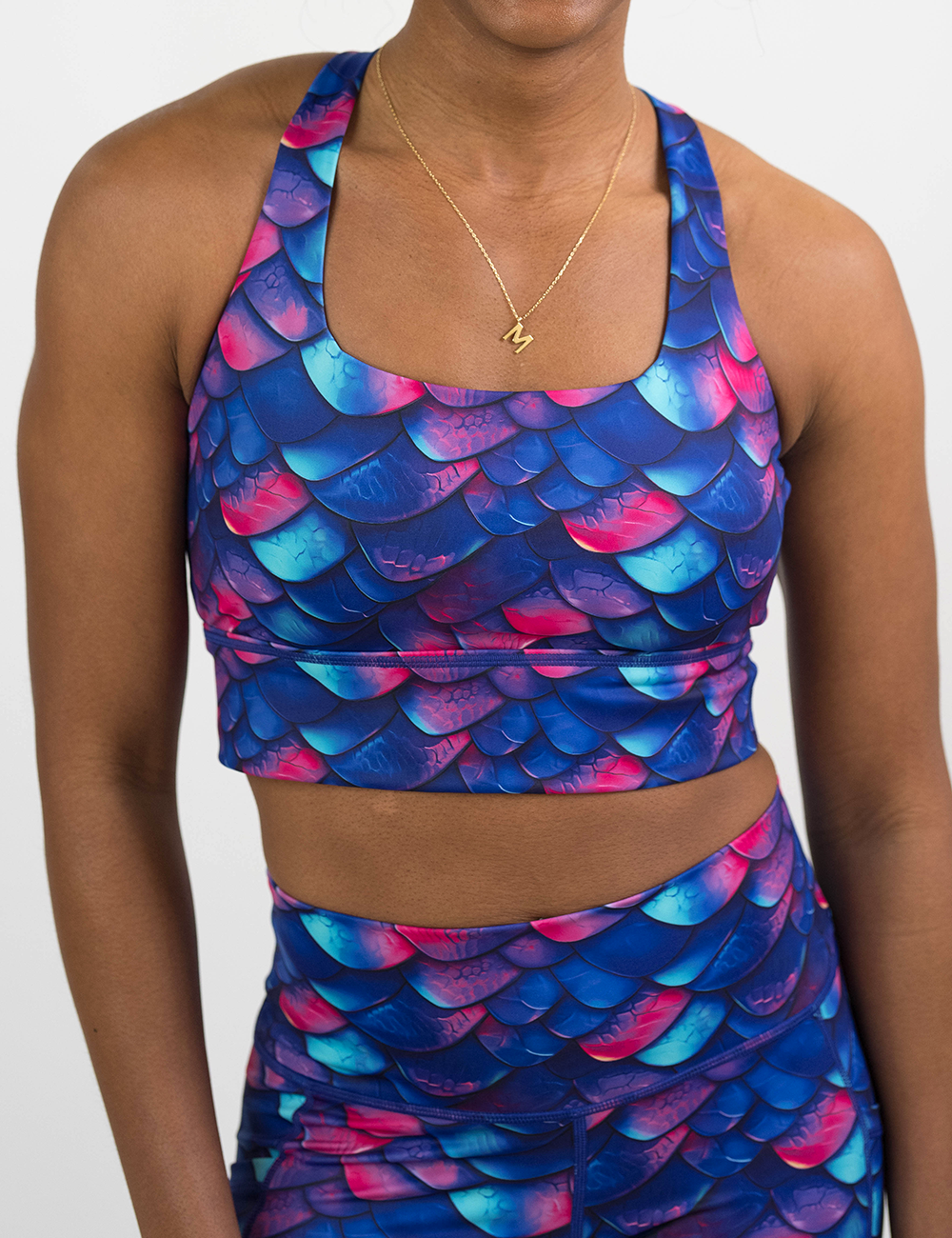 front of the blue, purple, and red colored dragon scale longline bra against a white background