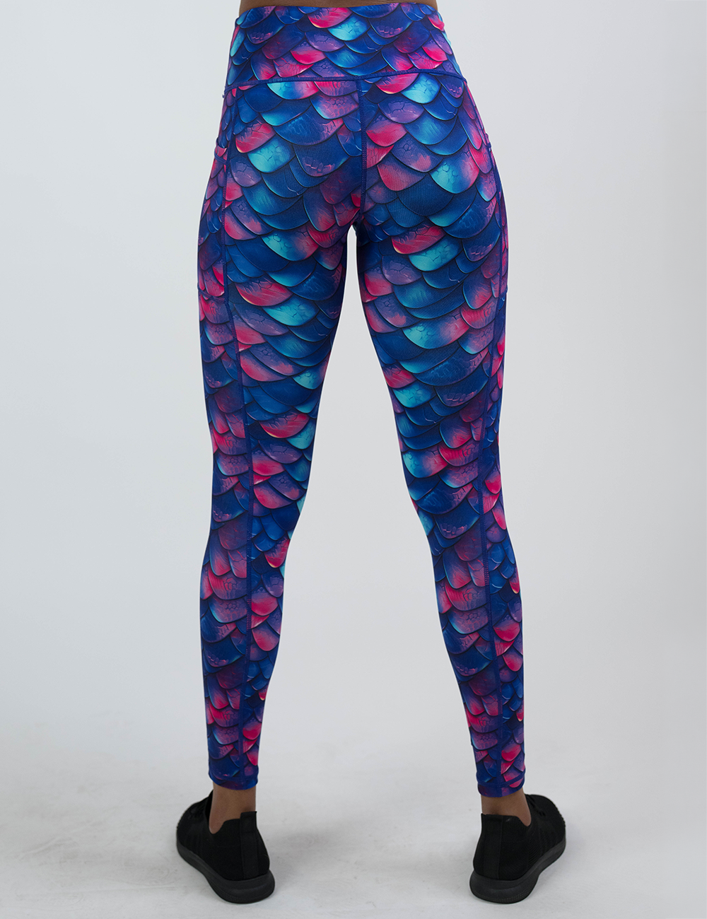 back of the blue, purple, and red colored dragon scale full length leggings against a white background