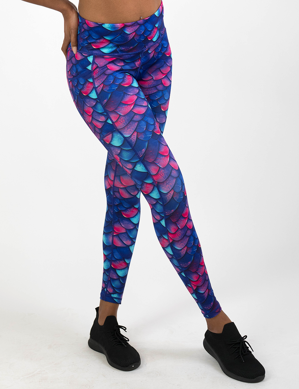 model wearing the  blue, purple, and red colored dragon scale full length leggings against a white background