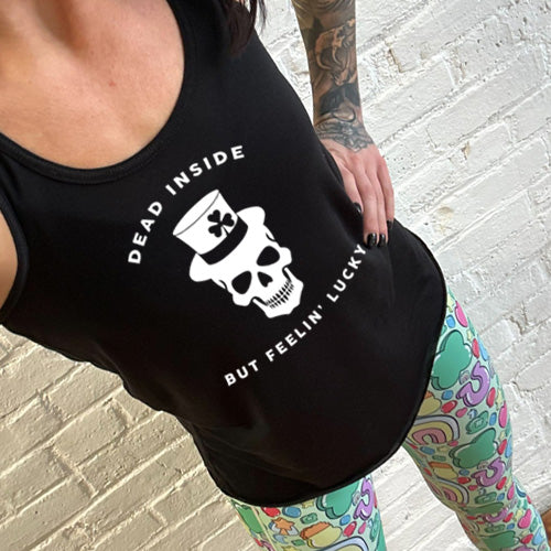 model wearing the black racerback tank top with a white leprechaun skull graphic on it