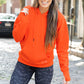 model wearing orange open back hoodie