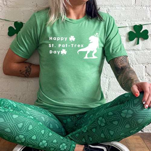 green unisex shirt that has a dinosaur and clover graphic on it