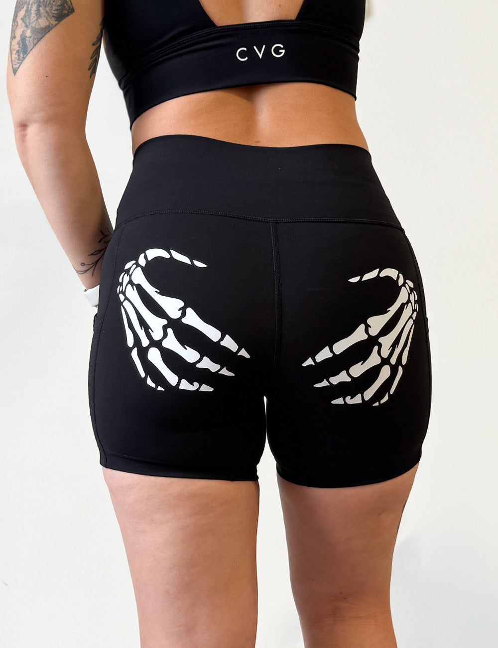 white skeleton hands on back of black shirts