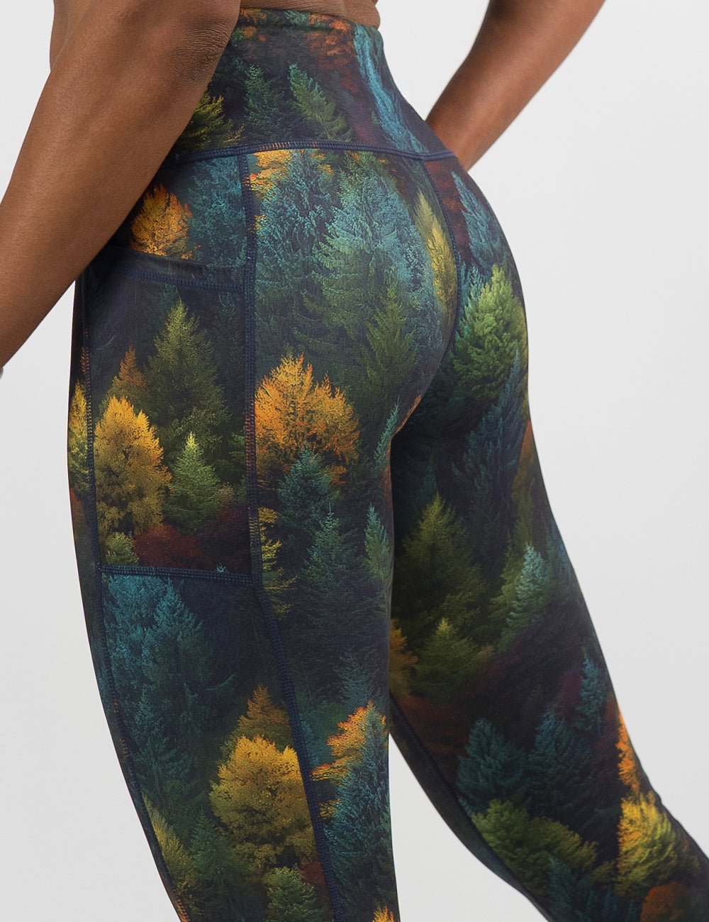 back of the orange, green, and bluish green trees leggings against a white background