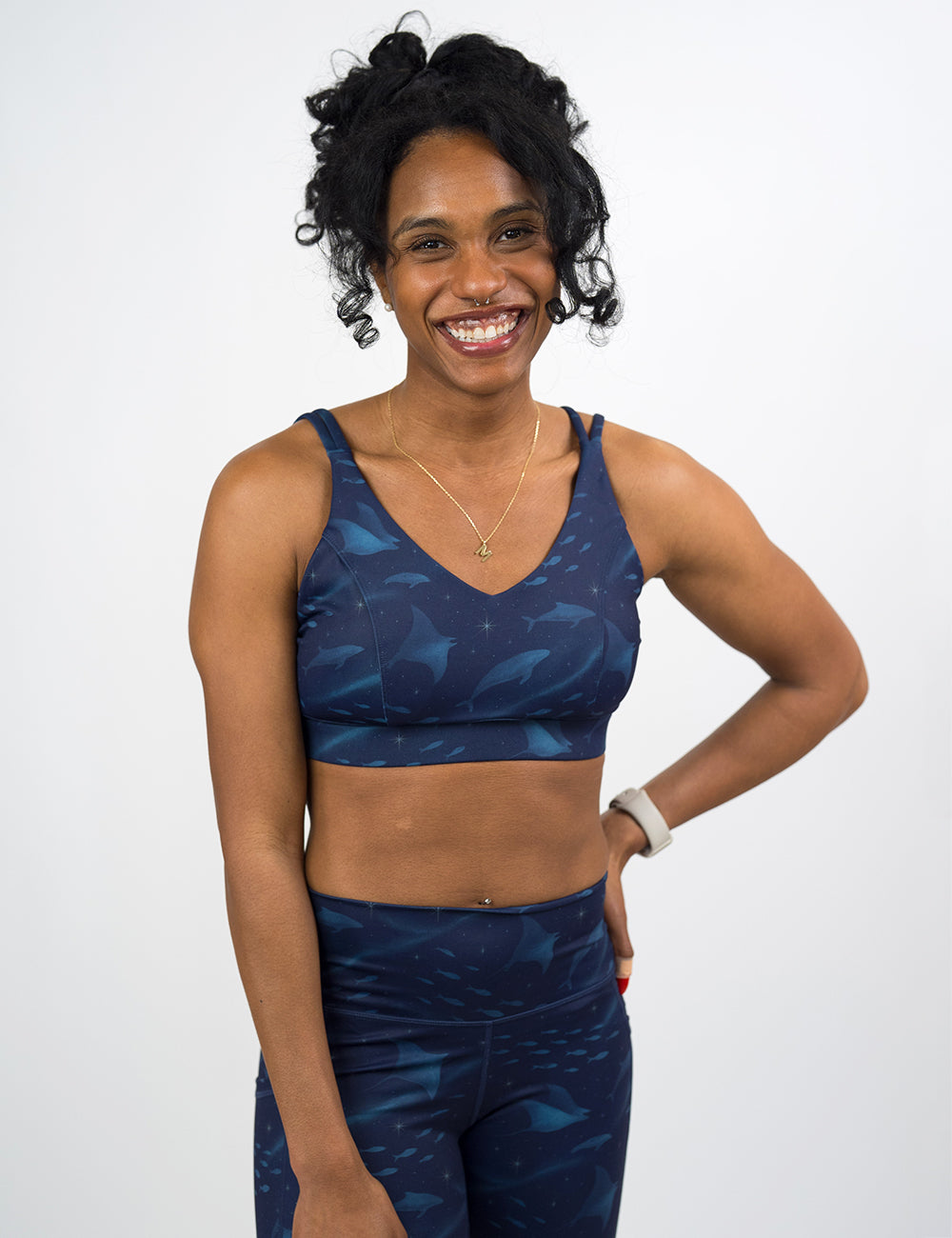 model wearing the dark blue ocean filled with sting rays, whales, and fish vitality bra against a white background